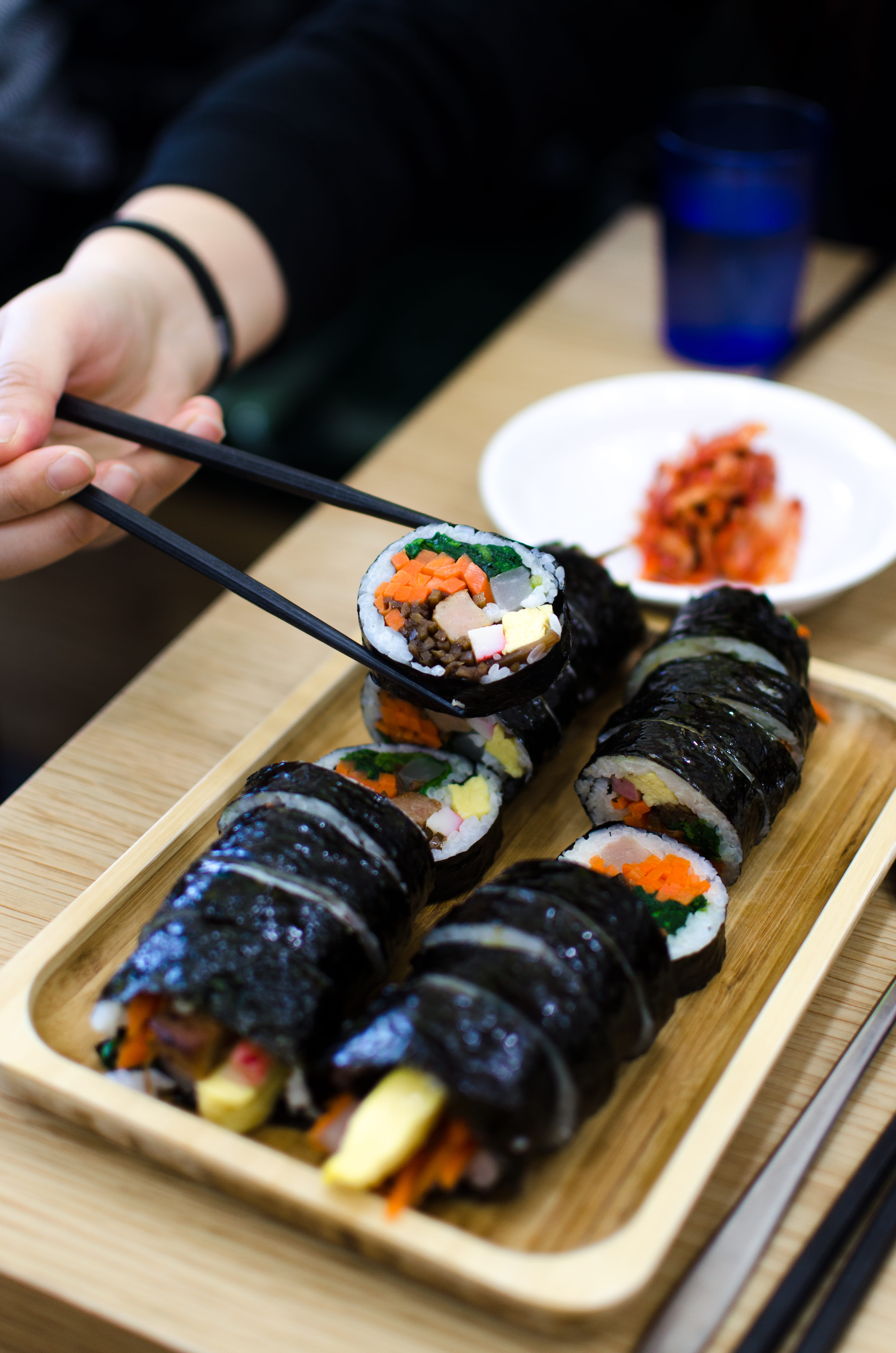 person picking sushi using chopsticks hand food tray plate 2k 4k