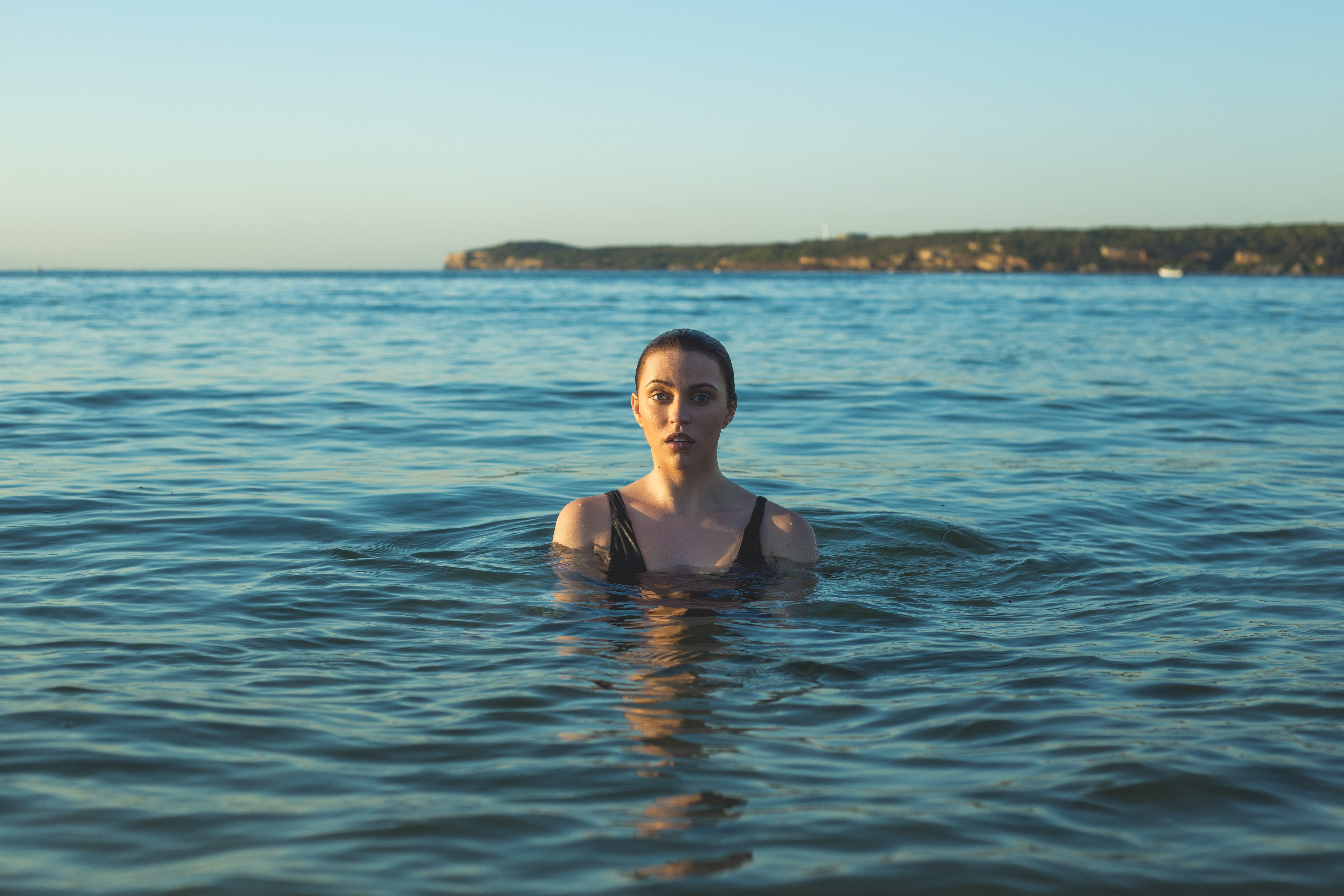 woman wearing black tank top swimming on sea at daytime beach 2k 4k 5k