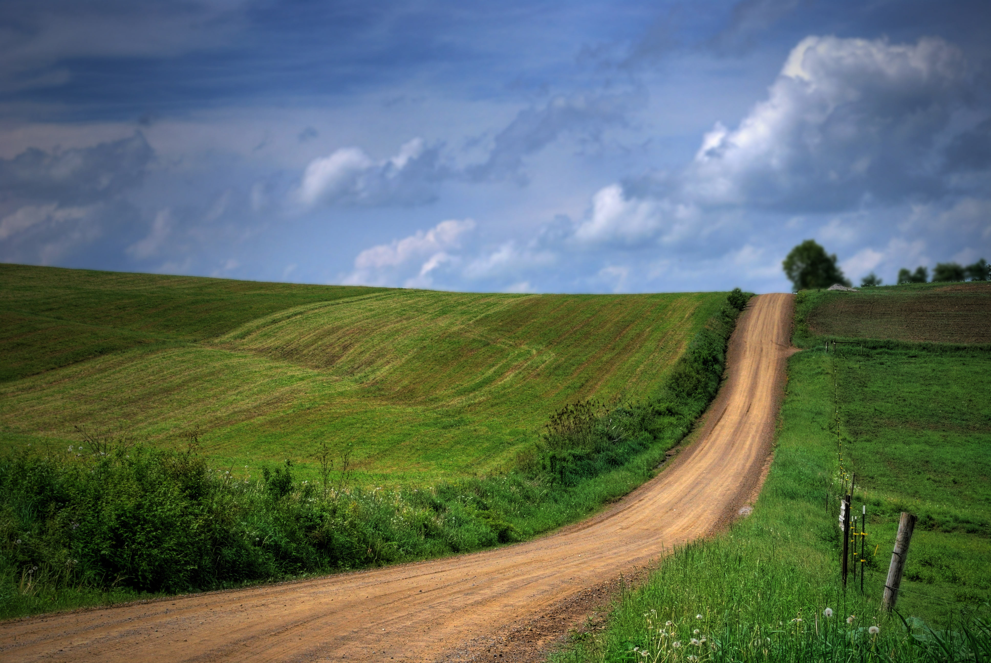 brown road between green grass under cloudy skies pennsylvania 2k 4k