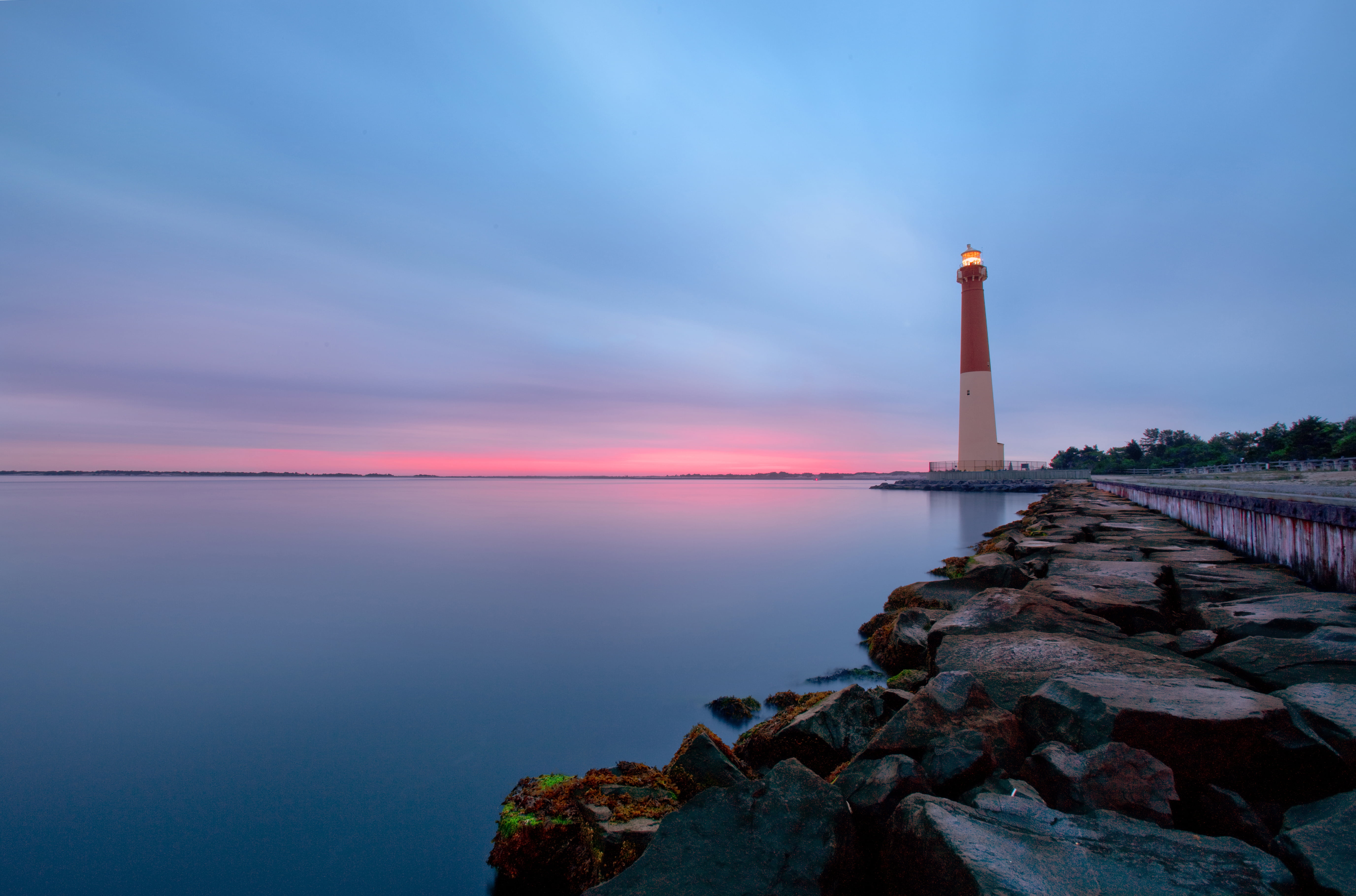 white and red lighthouse beside calm body of water Calm Before the Storm 2k 4k 5k