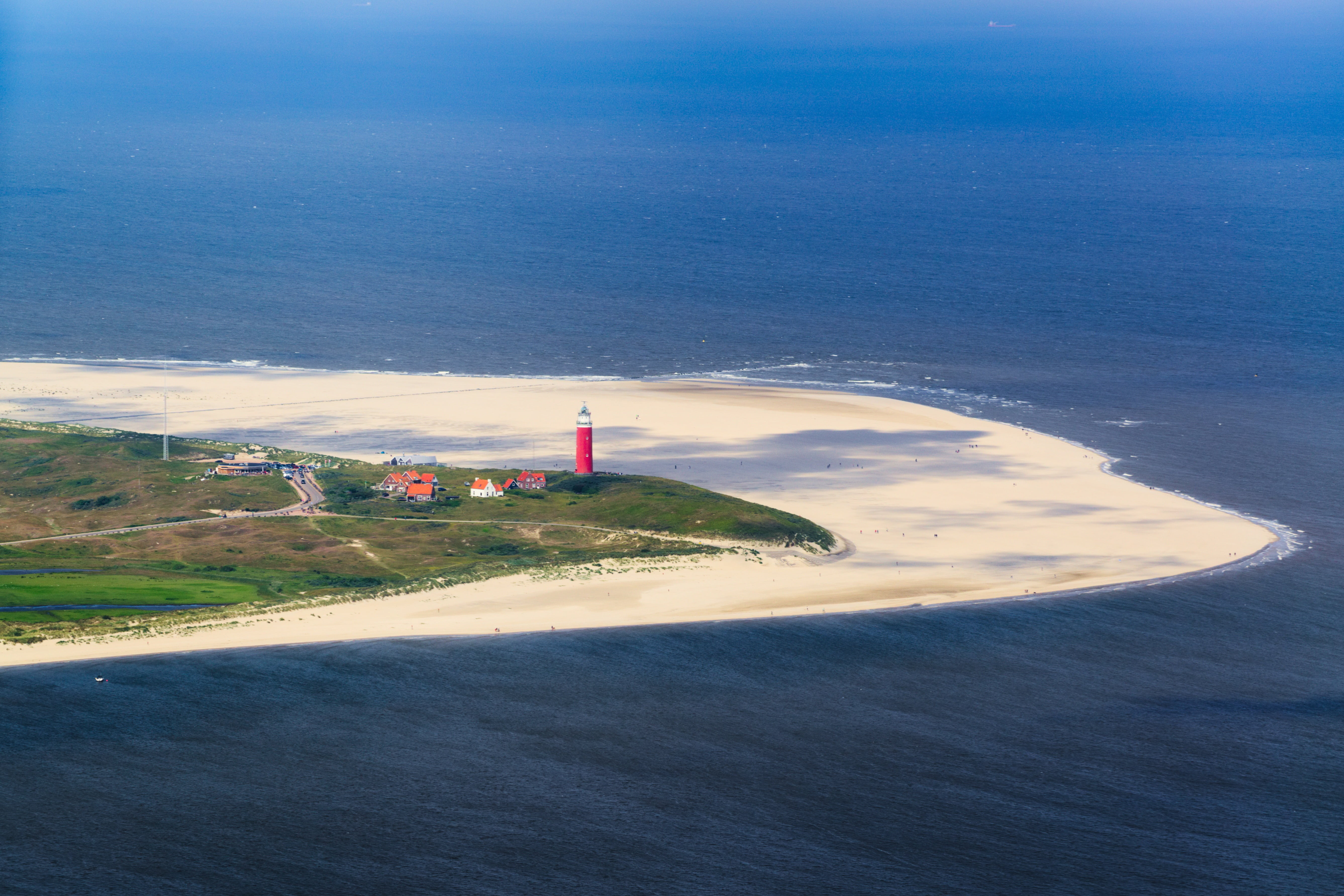 aerial photo of red and white lighthouse on seashore texel beach 2k 4k 5k