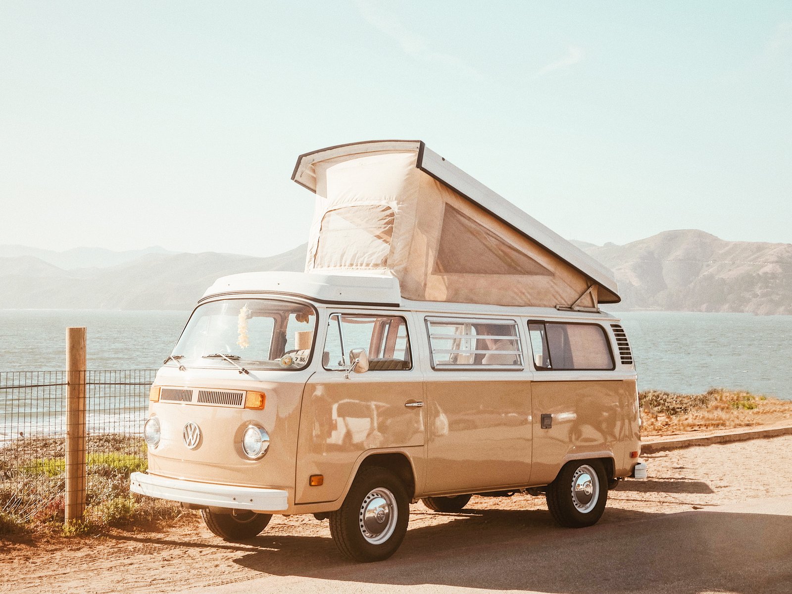 brown Volkswagen van near body of water at daytime and white parked the beach 2k 4k 5k