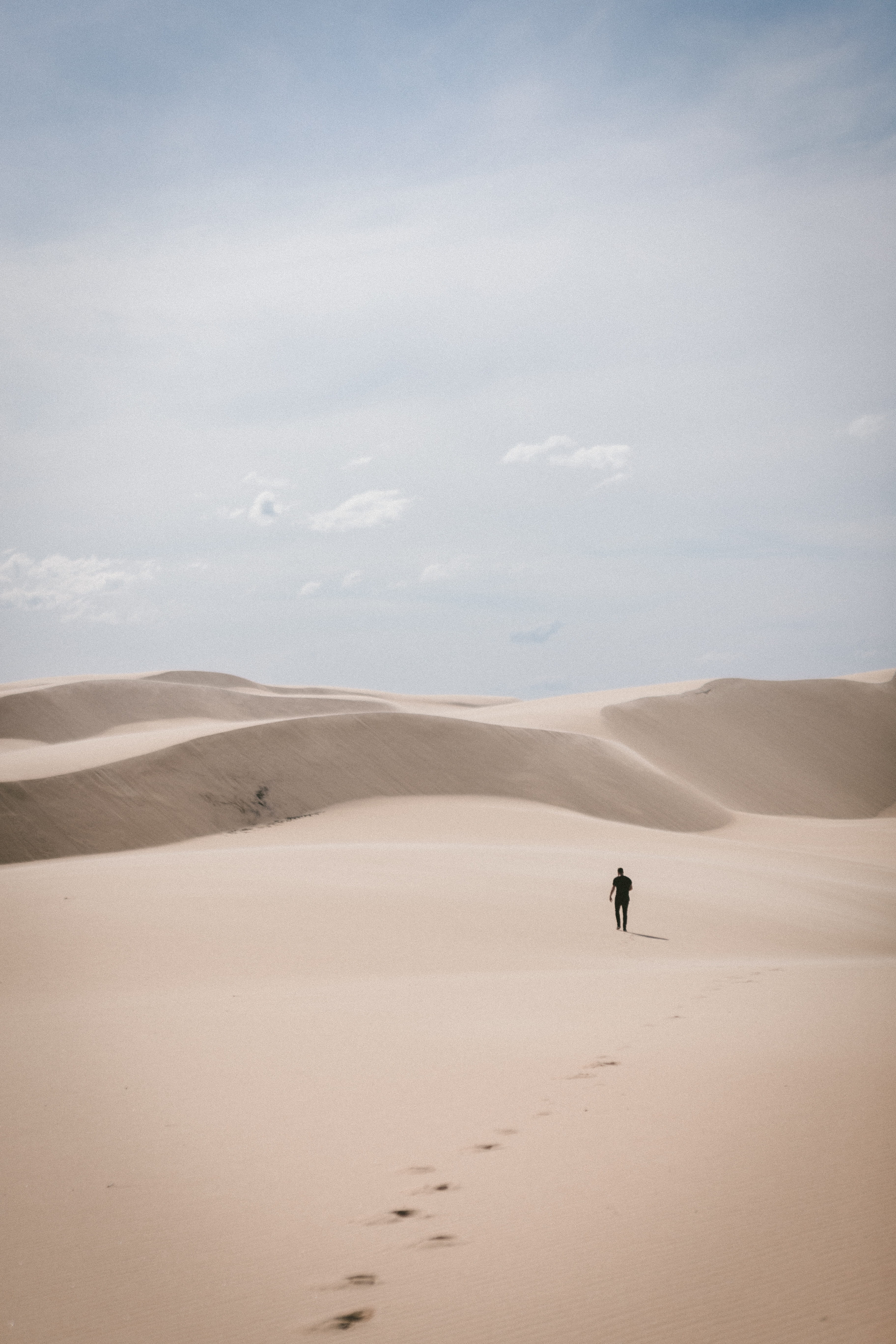 person waling on desert man walks during daytime dune 2k 4k
