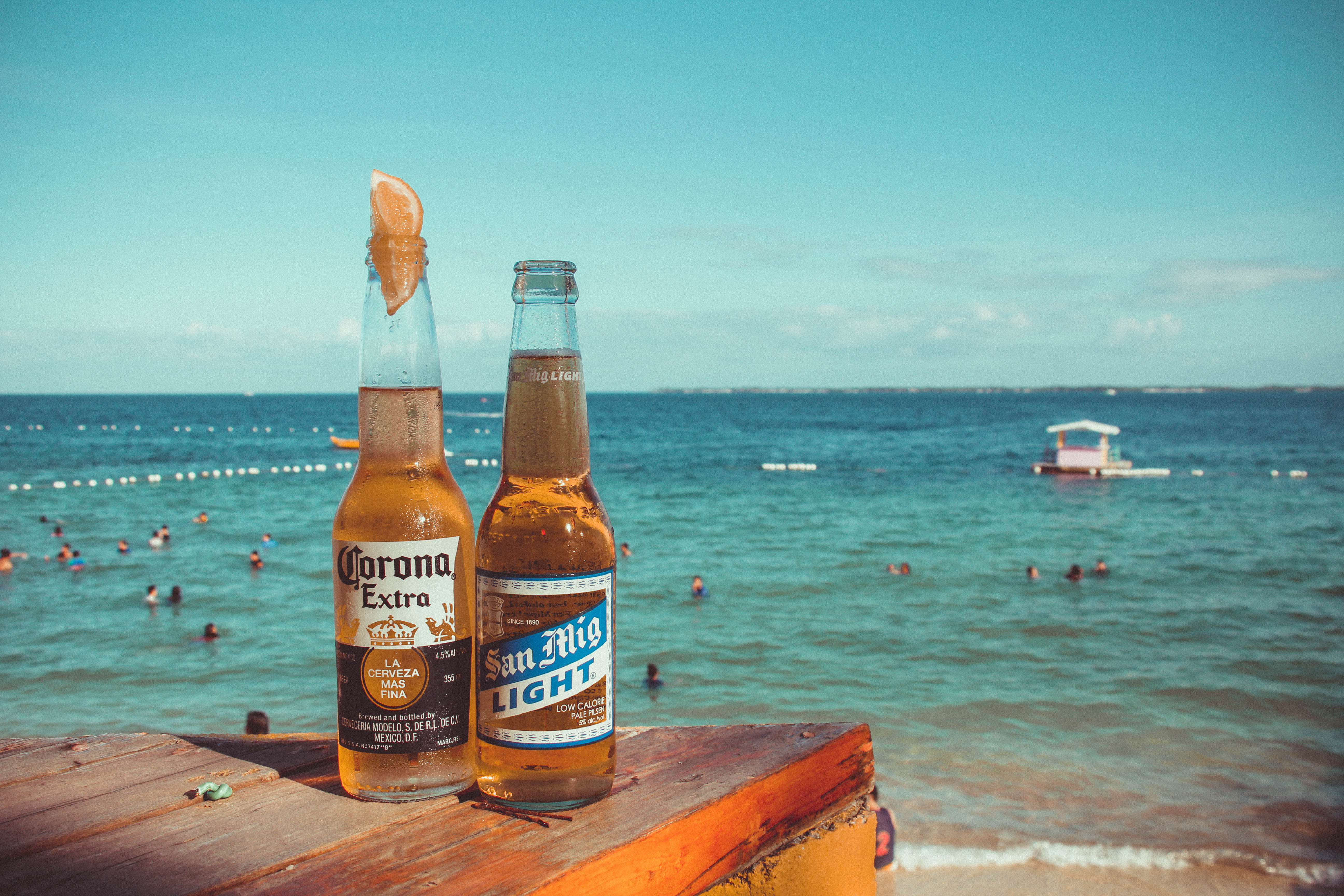 Two Corona Extra and San Mig Light Beers on Top of Brown Wooden Plank Near Beach 2k 4k 5k