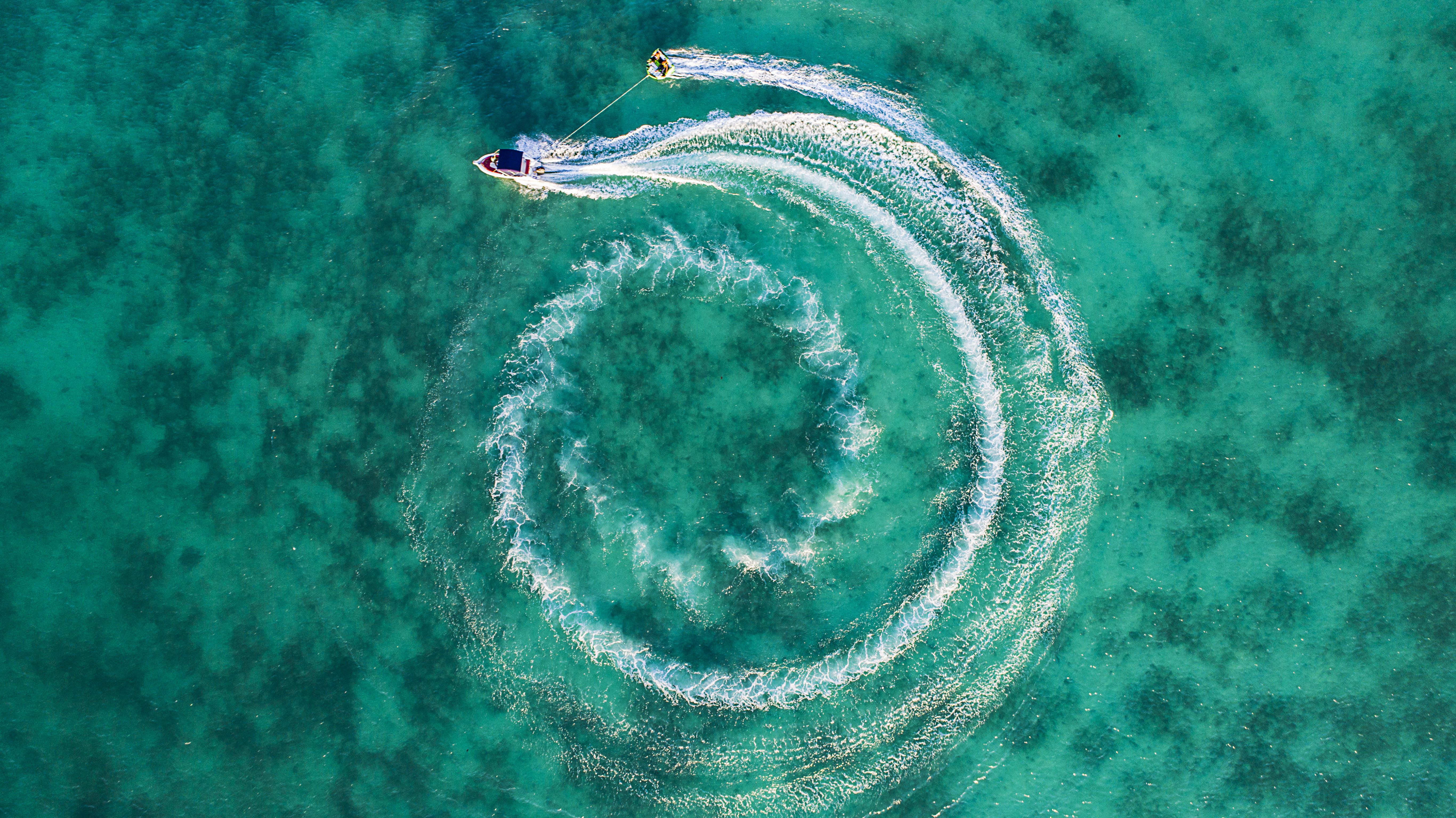 two boats on calm body of water top view photography speedboat maneuvering while pulling person wakeboard 2k 4k 5k