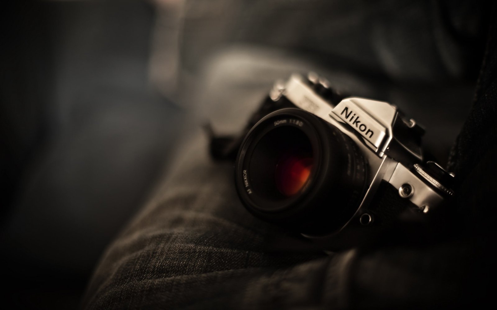 black and grey Nikon reel camera DSLR on person s lap 2k