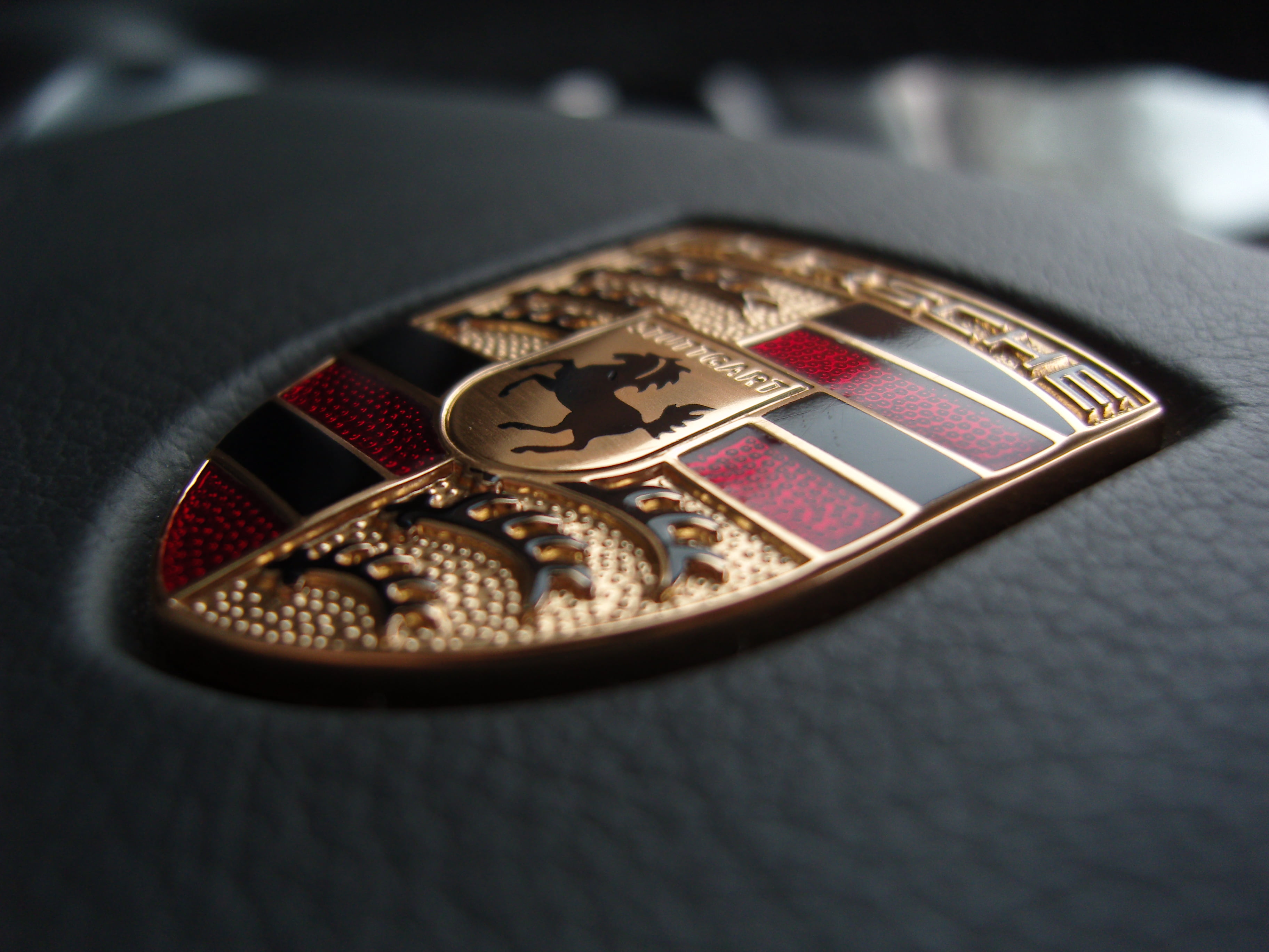 Porsche emblem macro photography logo car steering wheel 2k 4k