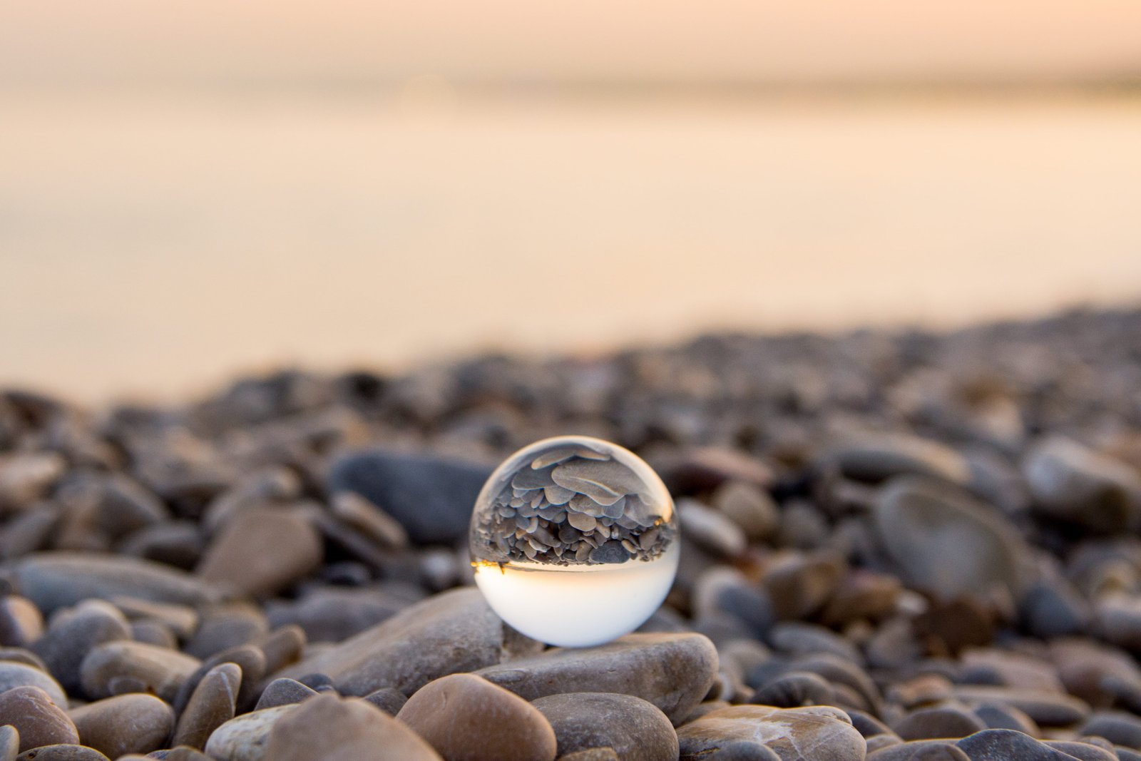 marble toy on stone ball glass sphere beach ocean sea bokeh 2k 4k 5k