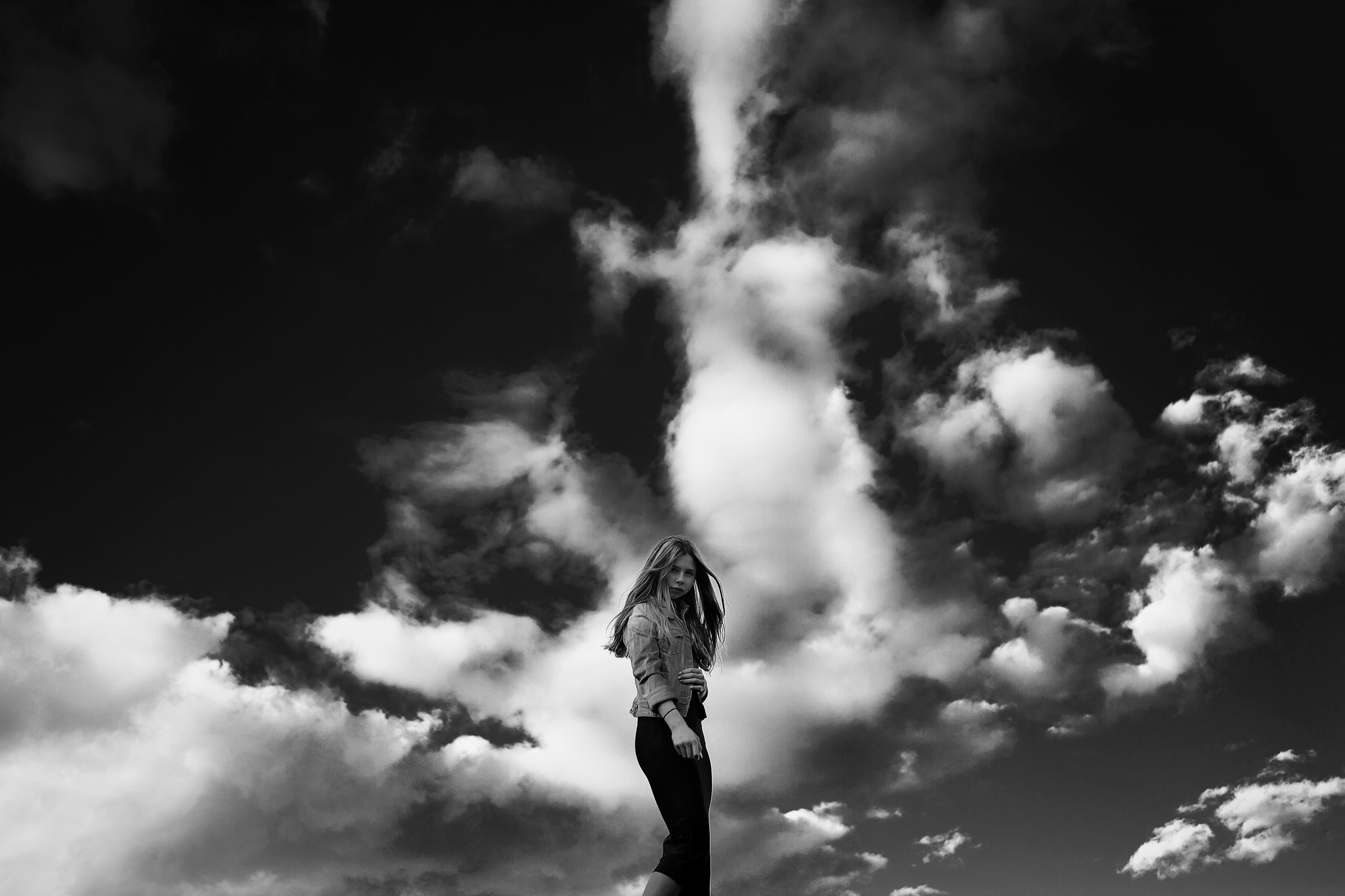 grayscale photography of woman with clouds on background against sky 2k 4k 5k