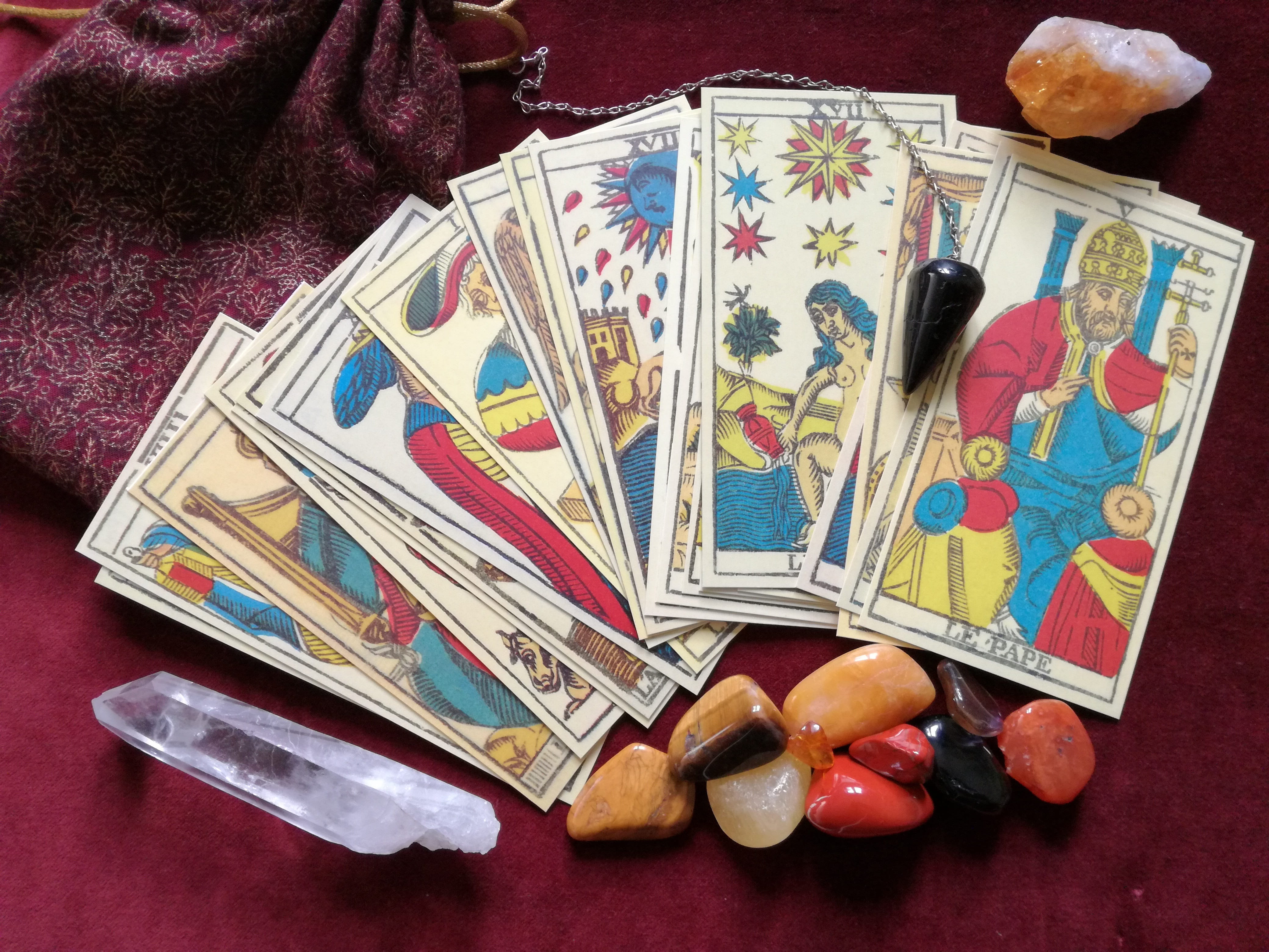 tarrot card beside stone tarot crystals pendulum occult esoteric 2k 4k