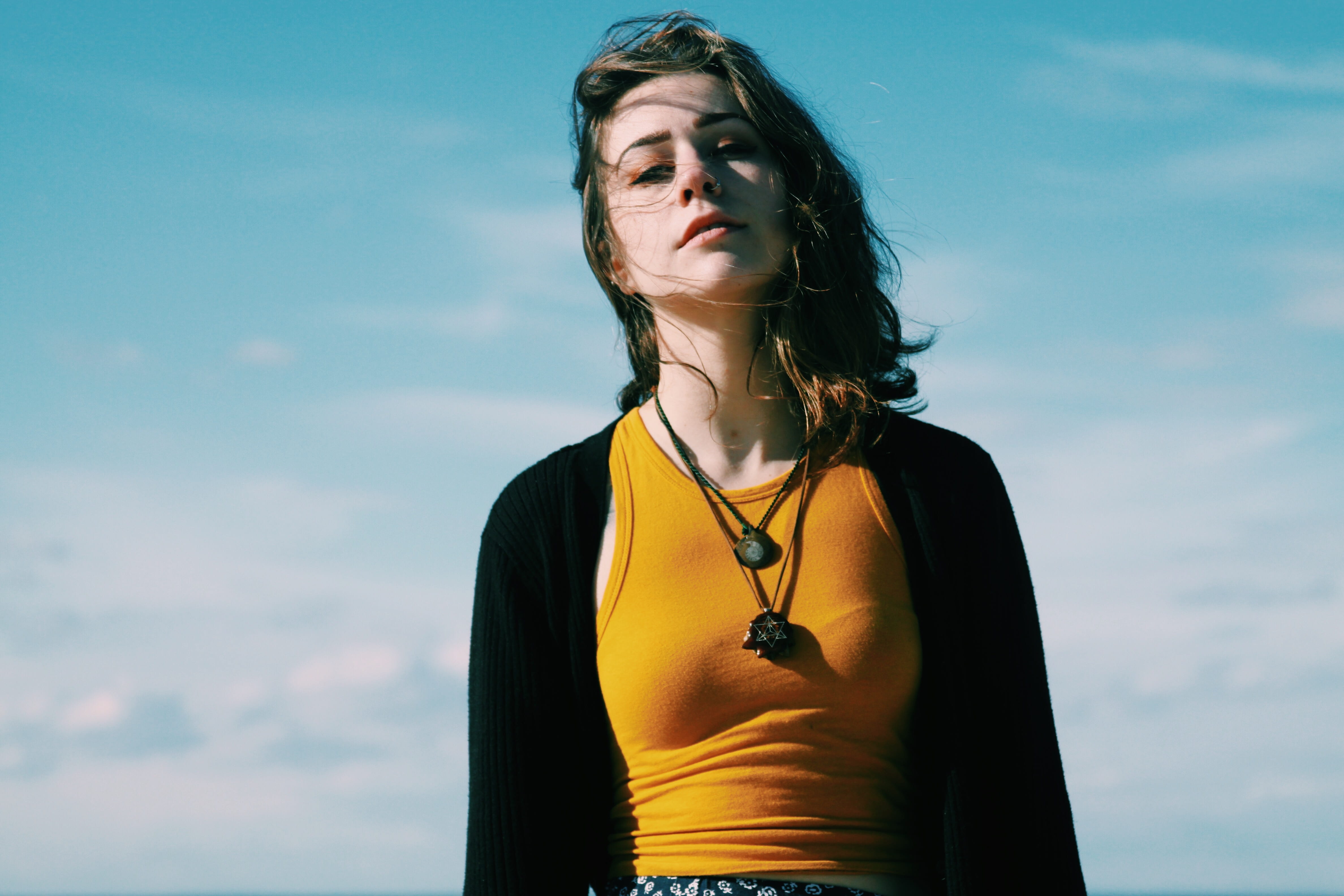 woman in black cardigan and brown tank top standing under blue sky 2k 4k 5k