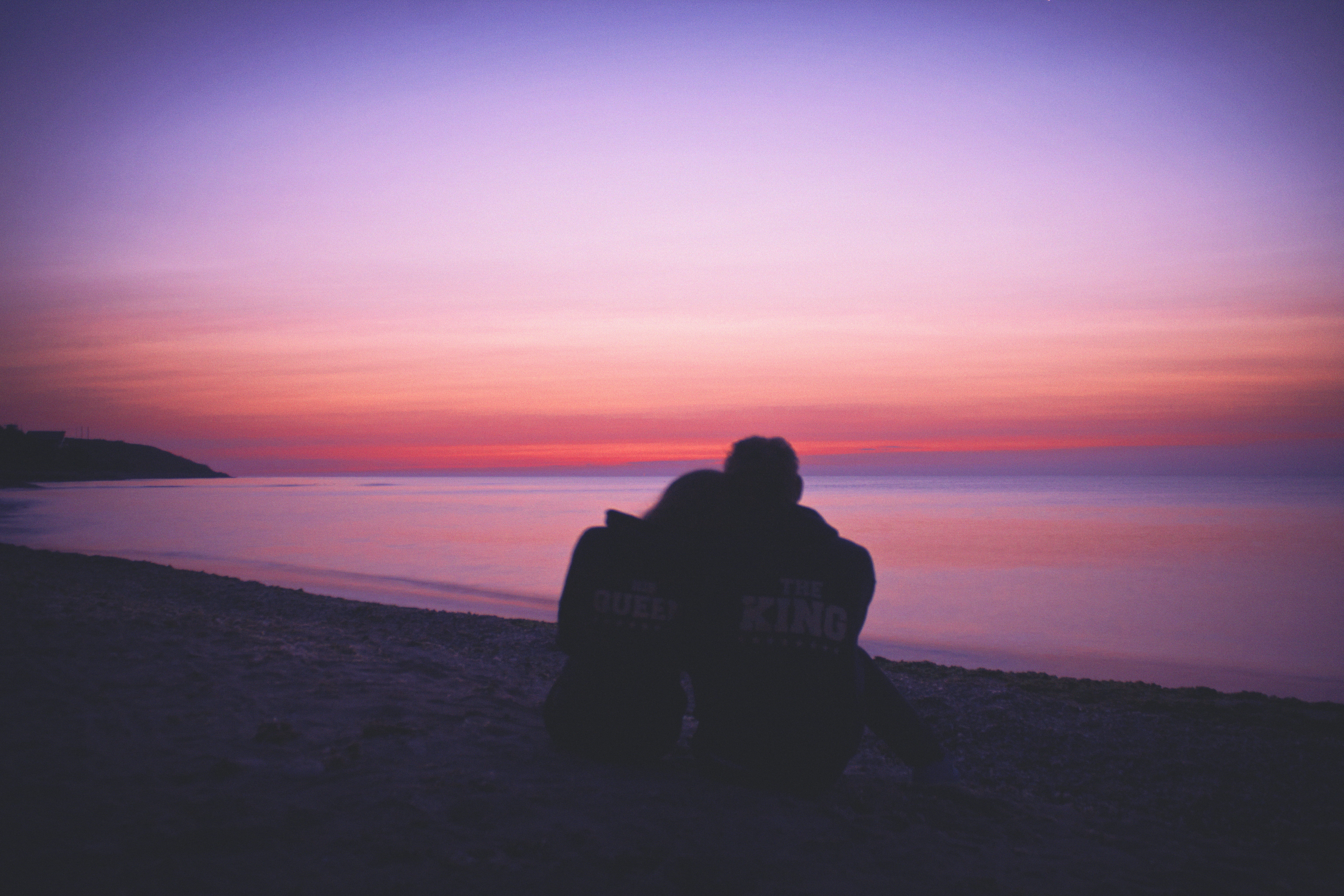man and woman hugging each other on seashore during sunset silhouette of couple sitting 2k 4k 5k