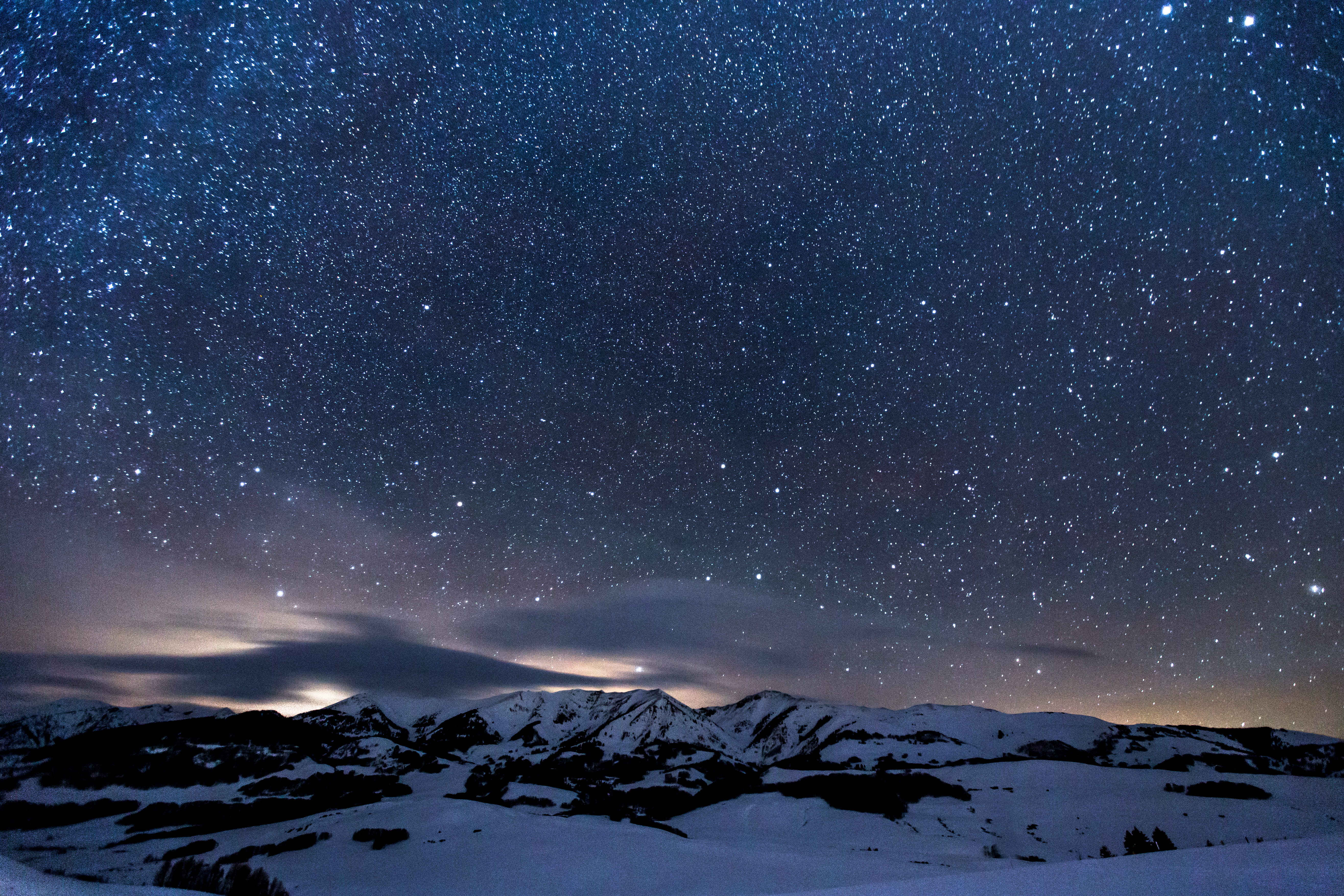 night sky with stars above snow landscape photo of mountain covered by during nighttime 2k 4k 5k
