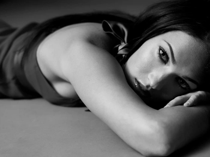 Megan Fox monochrome actress looking at viewer face lying down