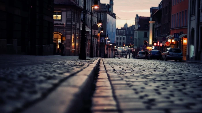 gray concrete pavement close up photography of near buildings and street lights