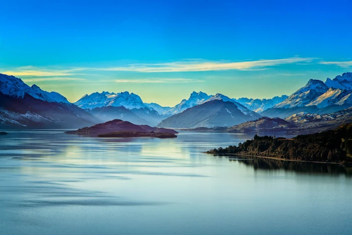 mountains near body of water during daytime On The Road to
