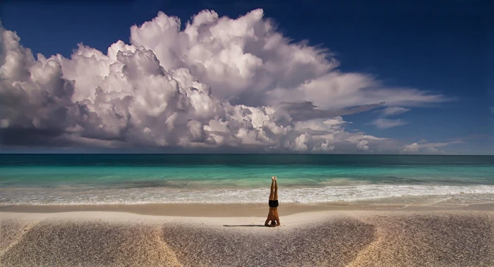 photo of person doing yoga exercise beside shore landscape nature