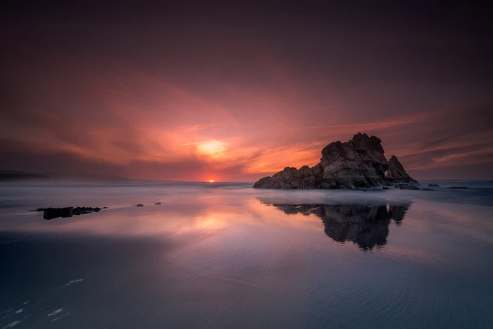 silhouette photography of rocky mountain between body water during sunset 2k