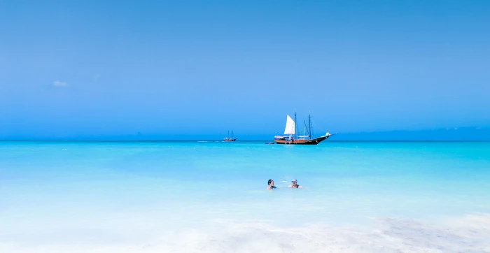 brown and white galleon boat on body of water near beach aruba 2k 4k