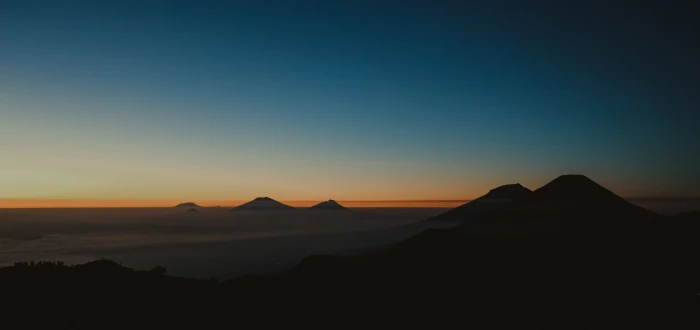 silhouette of mountains under blue and orange sky during golden hour 2k 4k 5k