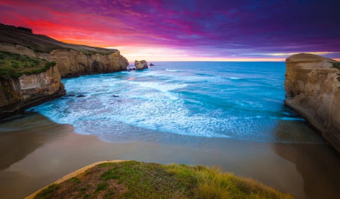 sunset cliff beach sea grass clouds coast water blue
