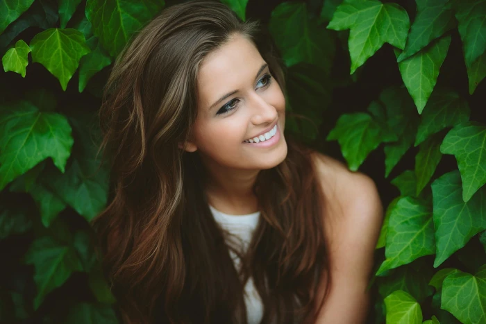 women's sleeveless top woman in white shirt beside leaf plant 2k