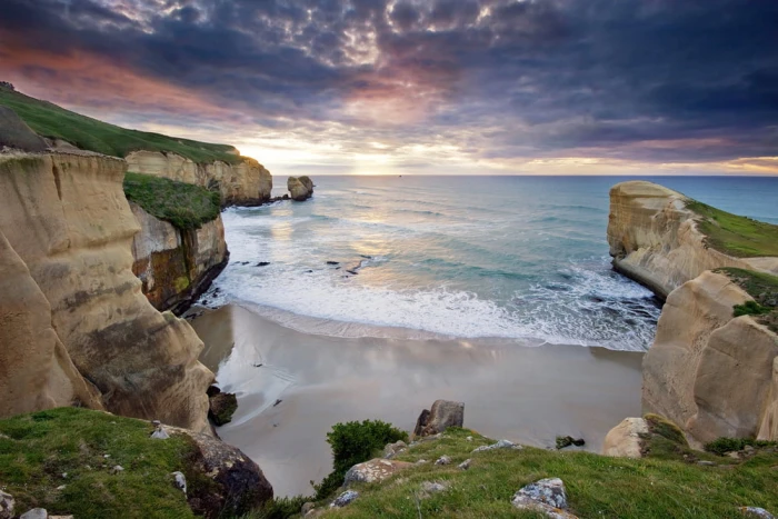 wavy sea near rocky mountain at cloudy sky Coastal Dreams tunnel beach