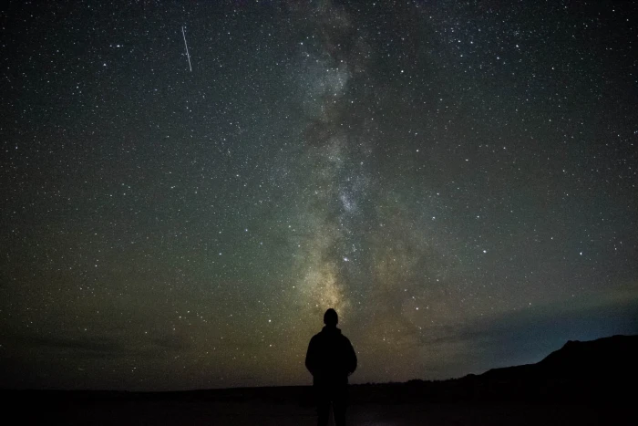 man on top of mountain person standing looking stars galaxy 2k