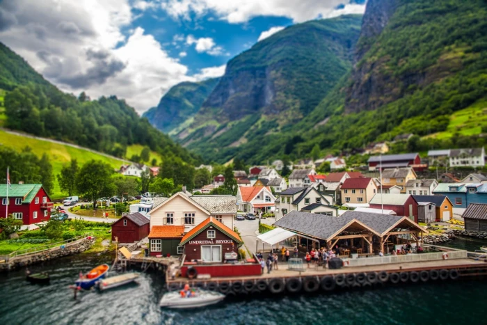 white motorboat and brown painted houses beside body of water 2k