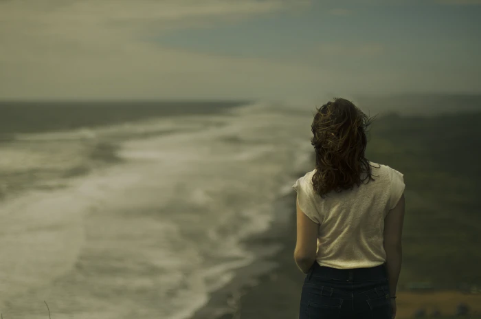 woman standing near seashore in white shirt facing ocean 2k 4k 5k