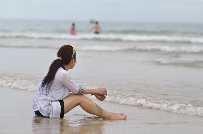 woman wearing white shirt sitting on seashore girl beach sad 2k 4k