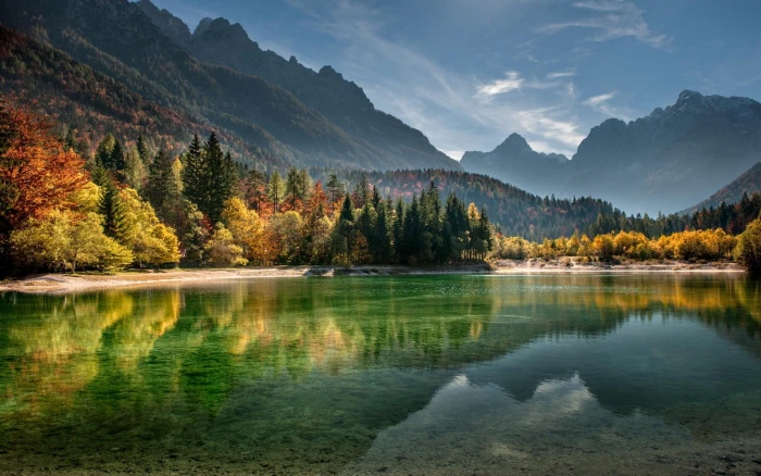 body of water calm surrounded with trees and mountains 1 2k