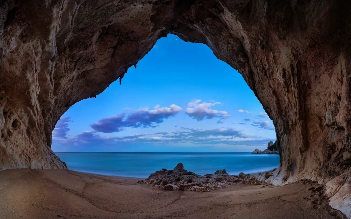 brown cave landscape nature beach sand rock sea clouds 2k