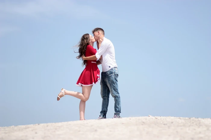 man and woman kissing while standing on white surface during daytime 2k 4k
