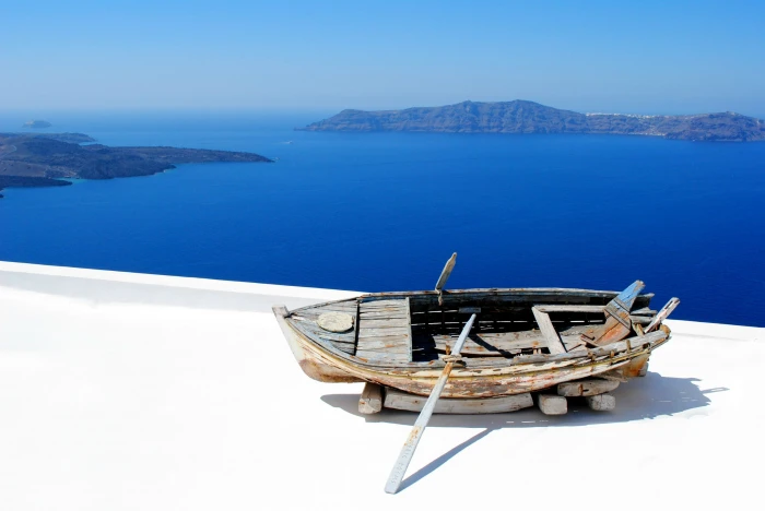 photo of beige wooden boat on top concrete floor santorini 2k