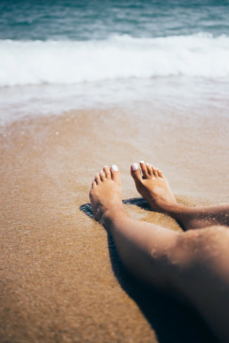 Sandy feet on the beach with waves in background 20 25 year old 2k