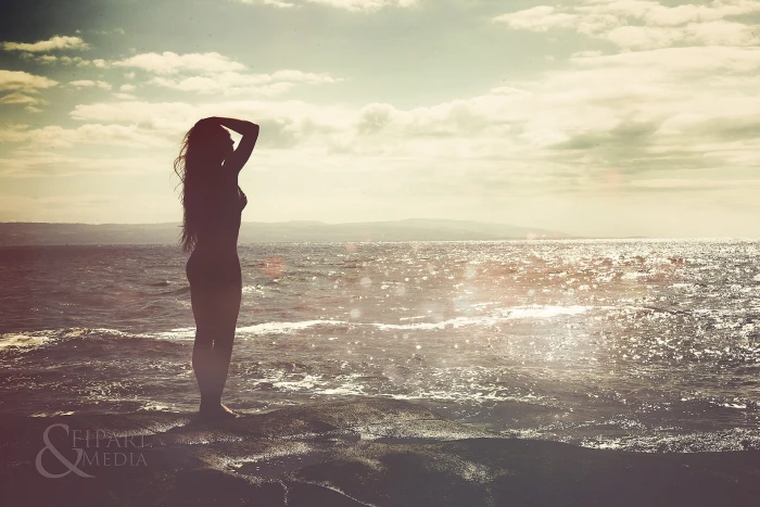 silhouette of woman standing near beach sea water long hair 2k