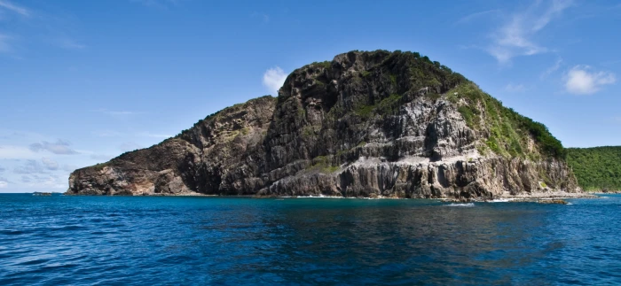 landscape photography of gray rock island surrounded by bodies water 2k