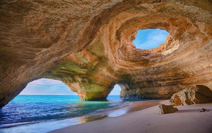 boulder and body of water Portugal cave beach rock sand 2k