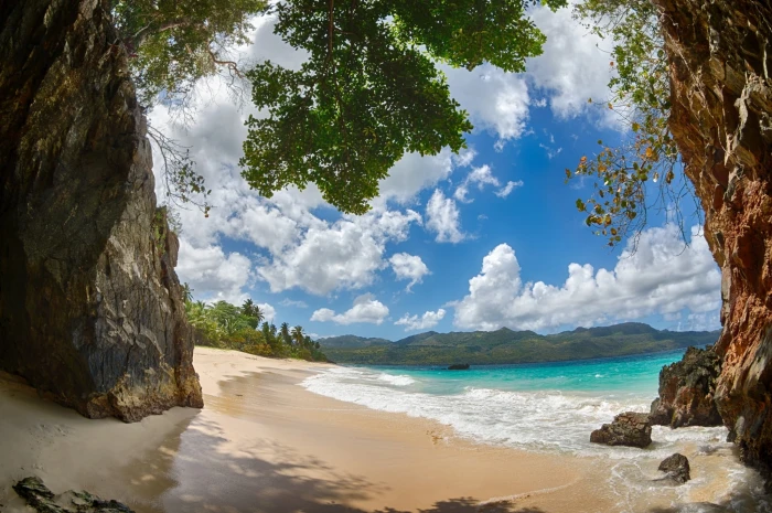 rock cave near body of water beach tropical sand mountains 2k