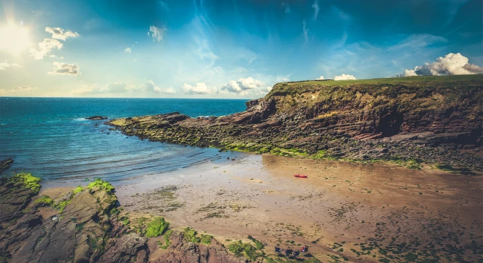 landscape photo of rock formation surrounded by body water 2k