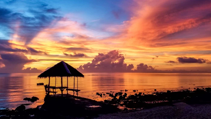 silhouette of cottage on beach nipa hut near body water during sunset 2k 4k