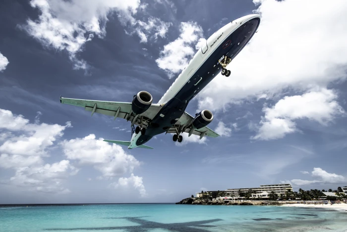 white aircraft above beach shoreline at daytime airplane transportation 2k 4k