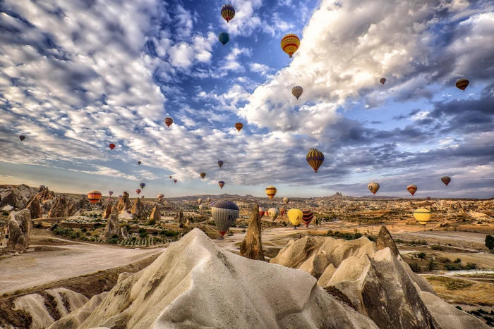 assorted color hot air balloons the sky clouds mountains rocks 2k