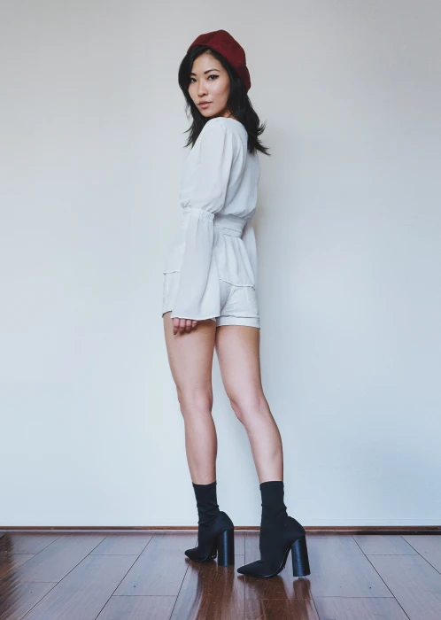 woman wearing white long sleeved dress and red snapback cap while standing on floor 2k