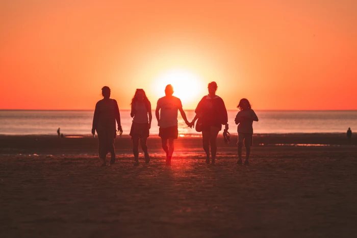 silhouette photo of five person walking on seashore during golden hour people sunset 2k 4k 5k