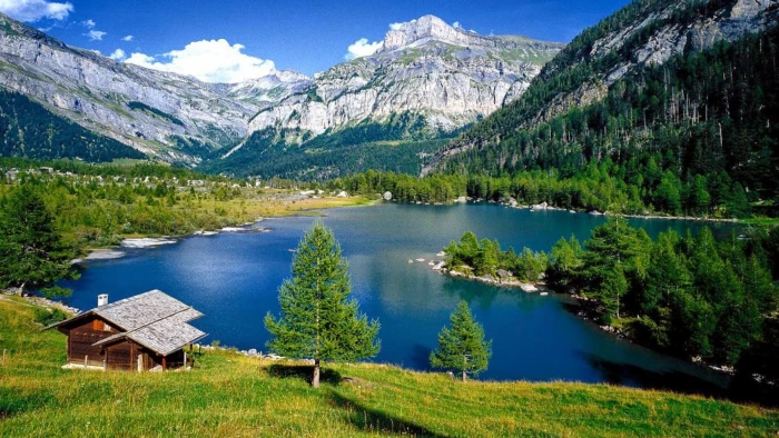 Rocky Mountains Forest With Pine Trees Lake Turquoise Blue Water Wooden House On Green Meadow Coast Switzerland Landscape Wallpaper Hd 2k