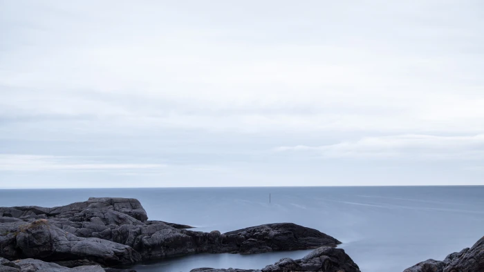black rock formation in blue body of water under cloudy sky during daytime 2k 4k 5k