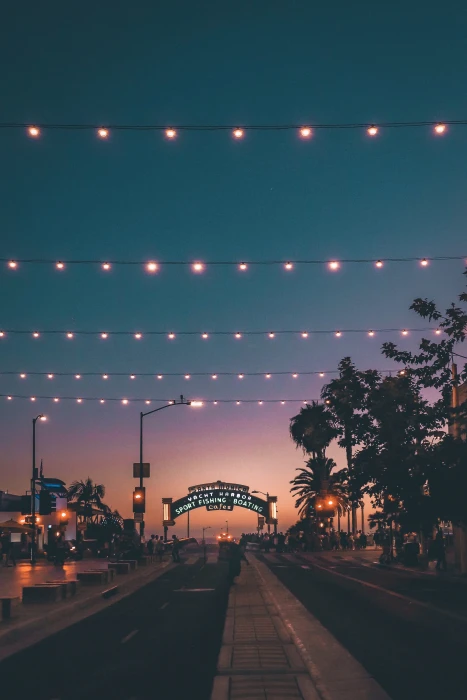 asphalted road at night with string lights on street pier sunset 2k