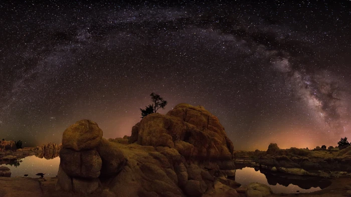 rock formation under starry night brown island near body of water 2k 4k